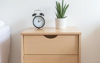 Minimalistisk sengebord i lyst træ med en enkel skuffe